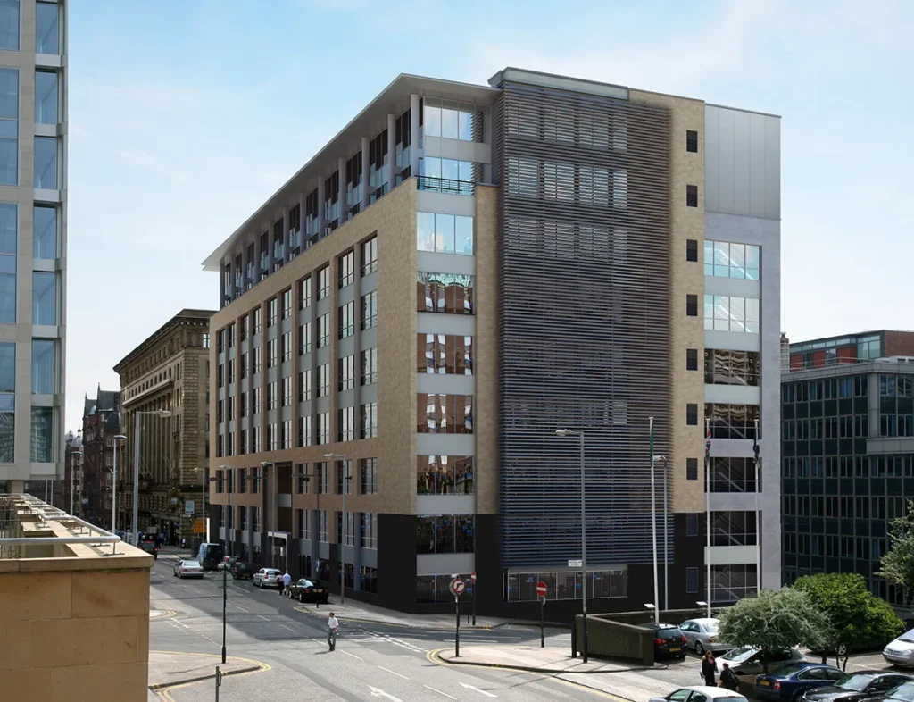 Modern office building on a city street with a blend of glass windows and stone exterior, featuring distinctive metal louvers for sun control.